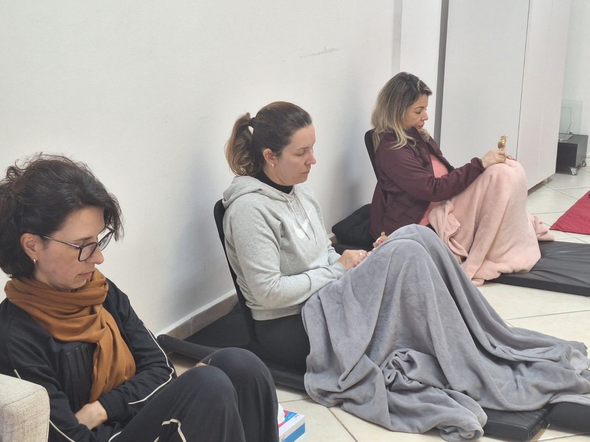 Grupo terapêutico em círculo, com mantas e almofadas